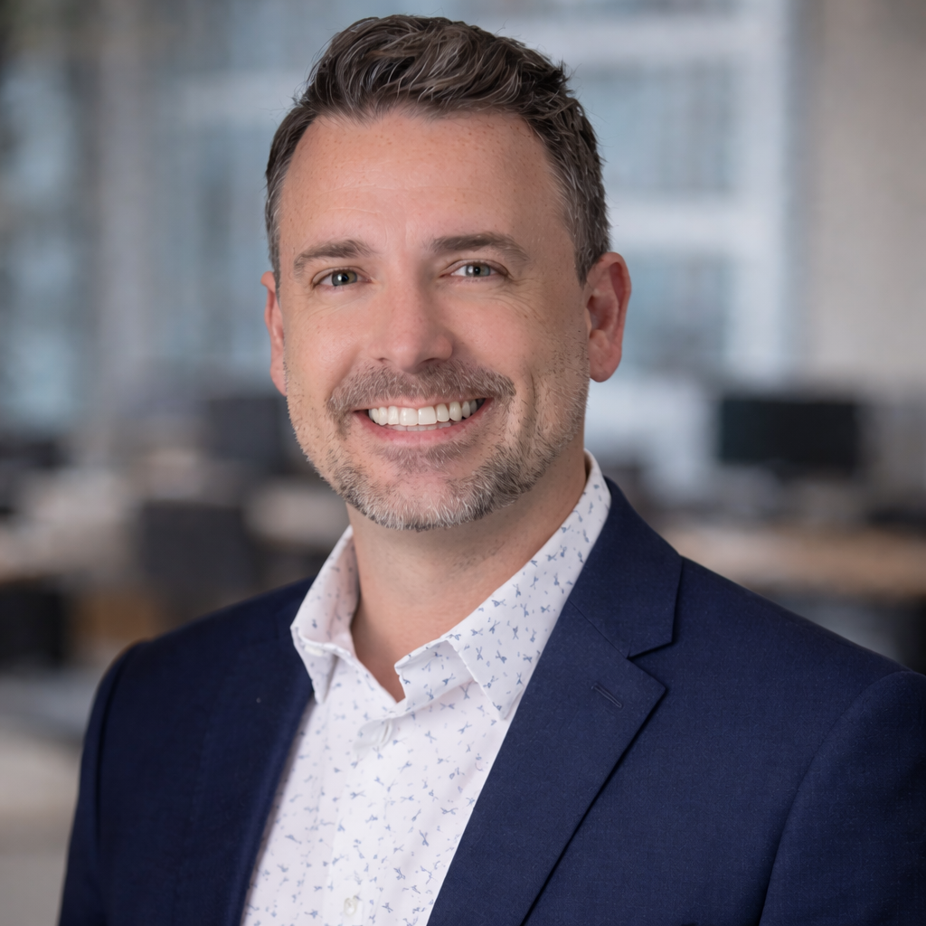 Dakota May, Chief Revenue Officer at Firefly Business Group, smiling in a professional setting with blurred office background.
